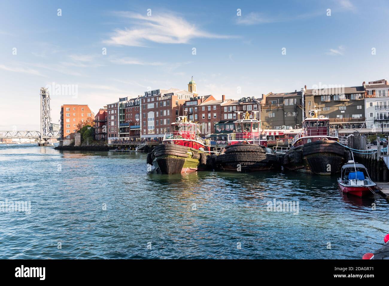 Vista dello skyline di Portsmouth in una soleggiata giornata autunnale. Tre rimorchiatore ormeggiato sono in primo piano. Foto Stock