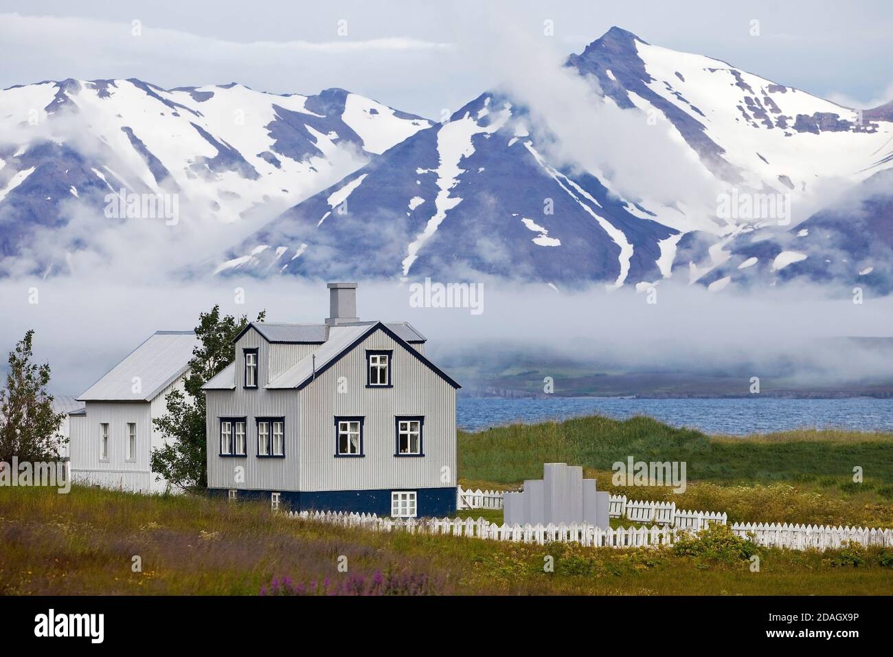 Casa a Dalvik di fronte al paesaggio di montagna, Islanda, Dalvik Foto Stock