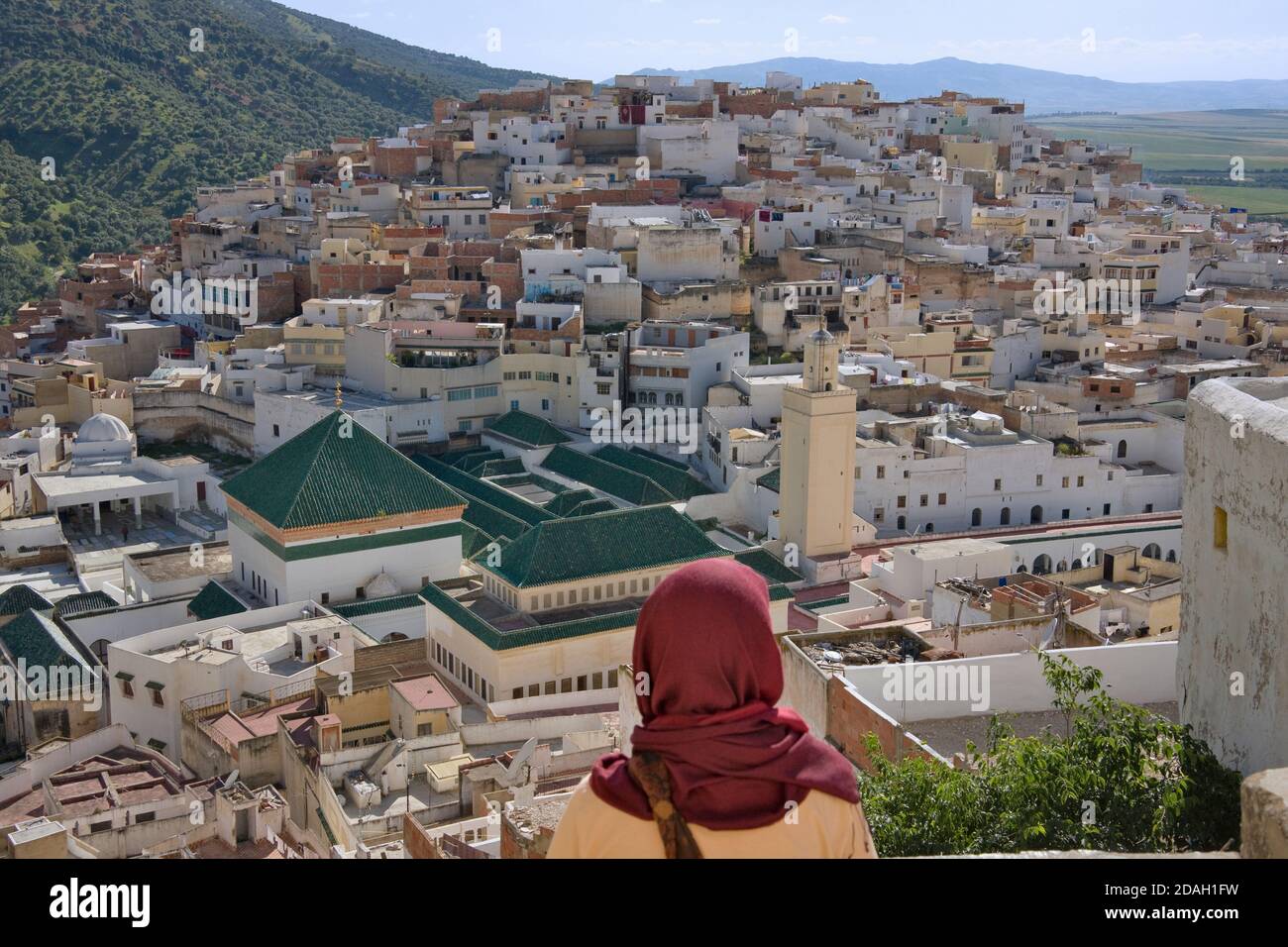 Donna che guarda Moulay Idriss dominato da Zaouia (scuola religiosa), Marocco Foto Stock