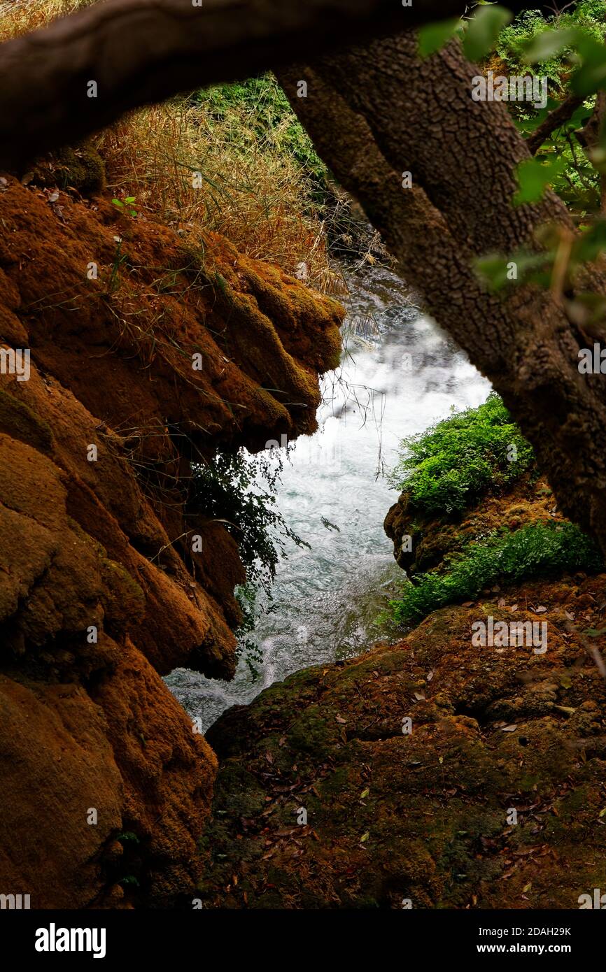 Vista sul fiume attraverso rocce e tronchi di alberi caduti Foto Stock