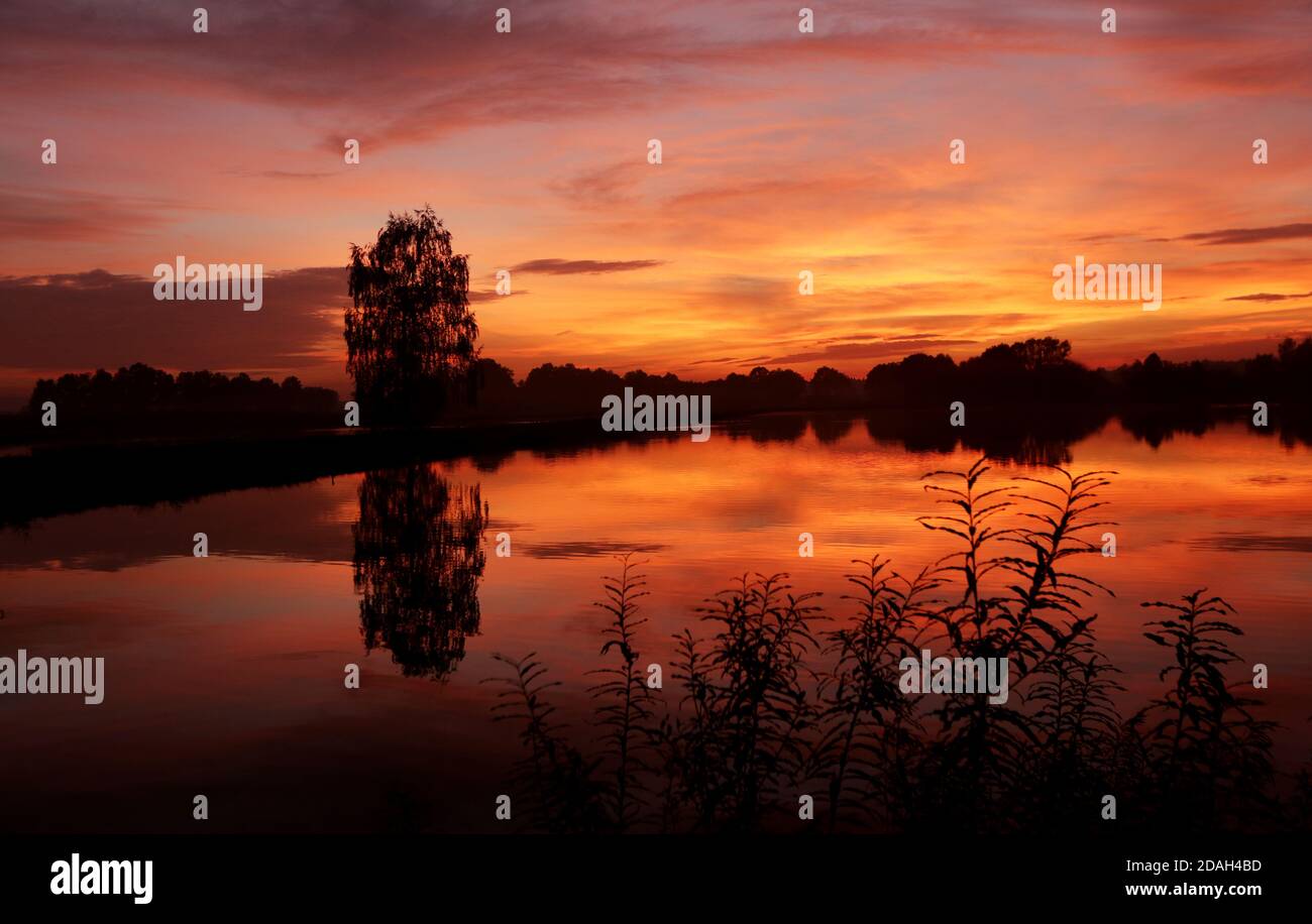 Il lago nei colori di un bellissimo tramonto d'autunno. Foto Stock