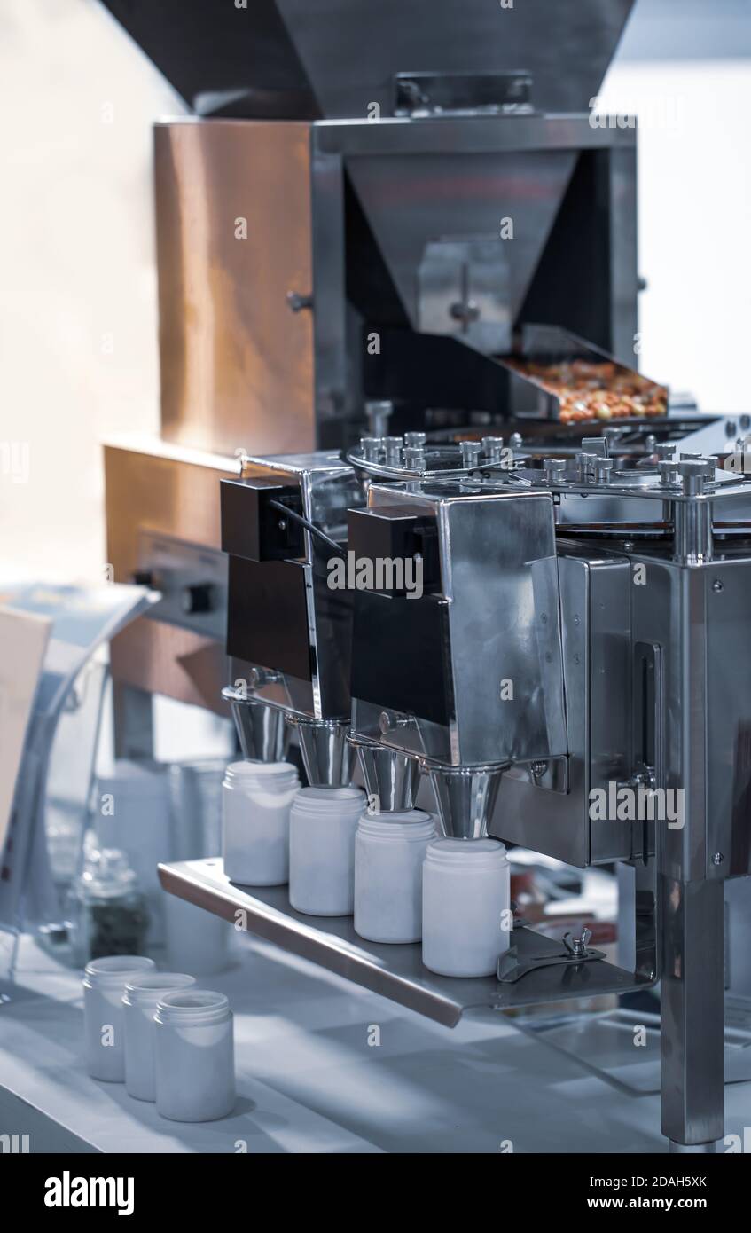 Macchina per il conteggio e il riempimento dei farmaci in capsula. Industria farmaceutica Foto Stock
