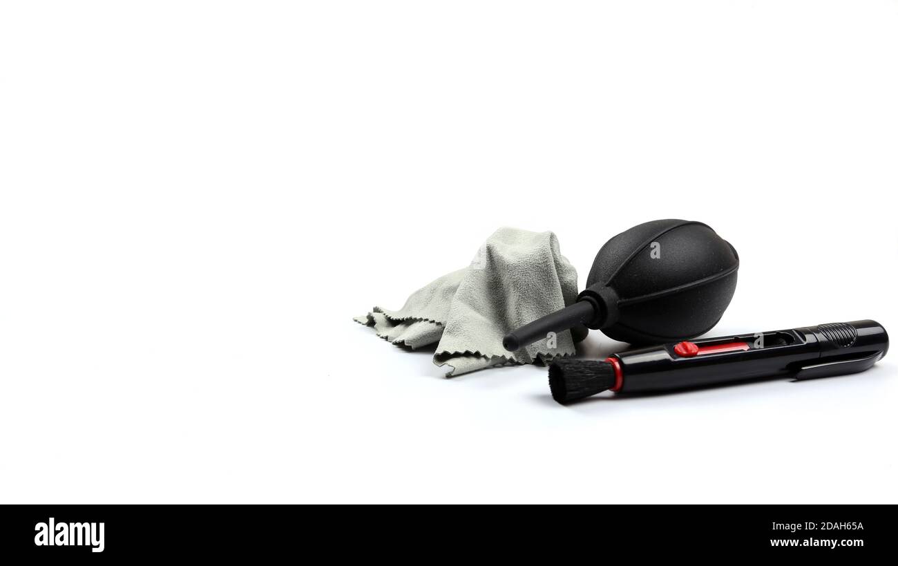 Kit di pulizia della fotocamera (soffiatore della polvere, penna per lenti e panno per la pulizia delle fibre) per la pulizia della fotocamera. Messa a fuoco selettiva con sfondo bianco Foto Stock