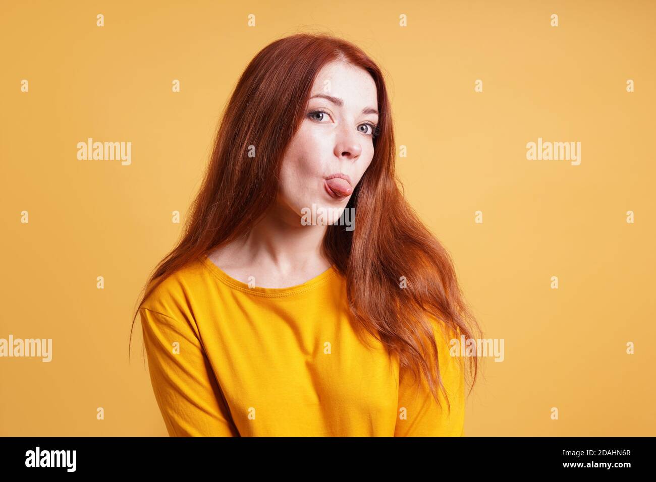 giovane donna sassosa silly cheeky che si stacca la lingua Foto Stock