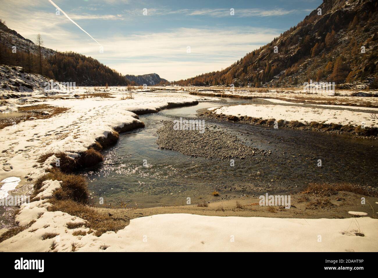 Il fiume Duino che scorre nello scenario della Preda Rossa nel tardo autunno, con la prima neve in una giornata di sole. Val Masino, Lombardia, Italia. Foto Stock