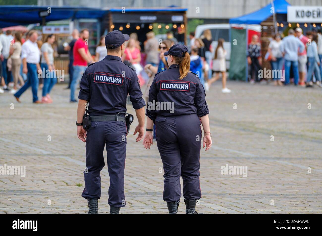 Poliziotti pattugliando piazza durante la fiera Foto Stock