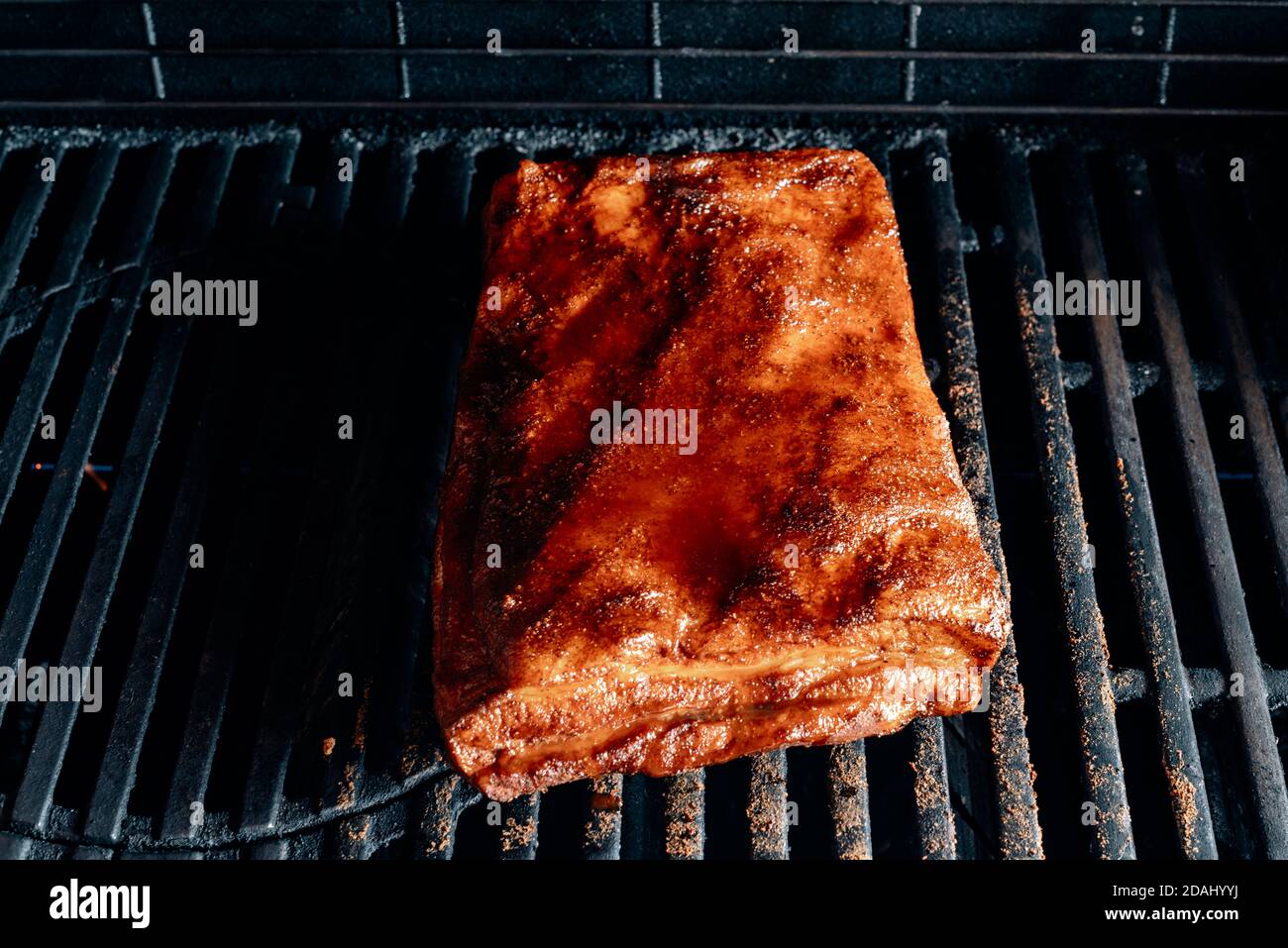 grigliare lentamente le costolette con la pancetta sulla griglia Foto Stock