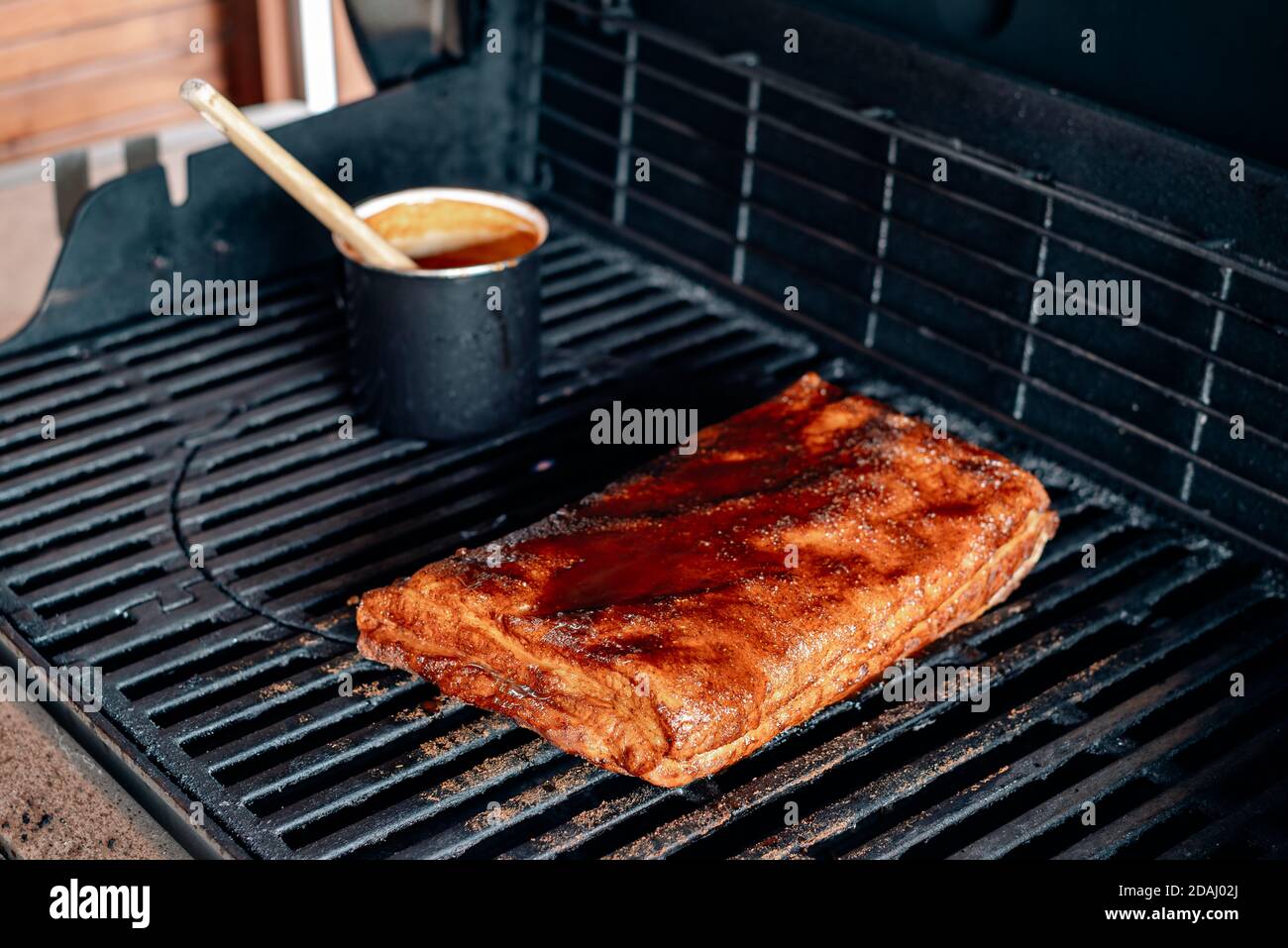 grigliare lentamente le costolette con la pancetta sulla griglia Foto Stock