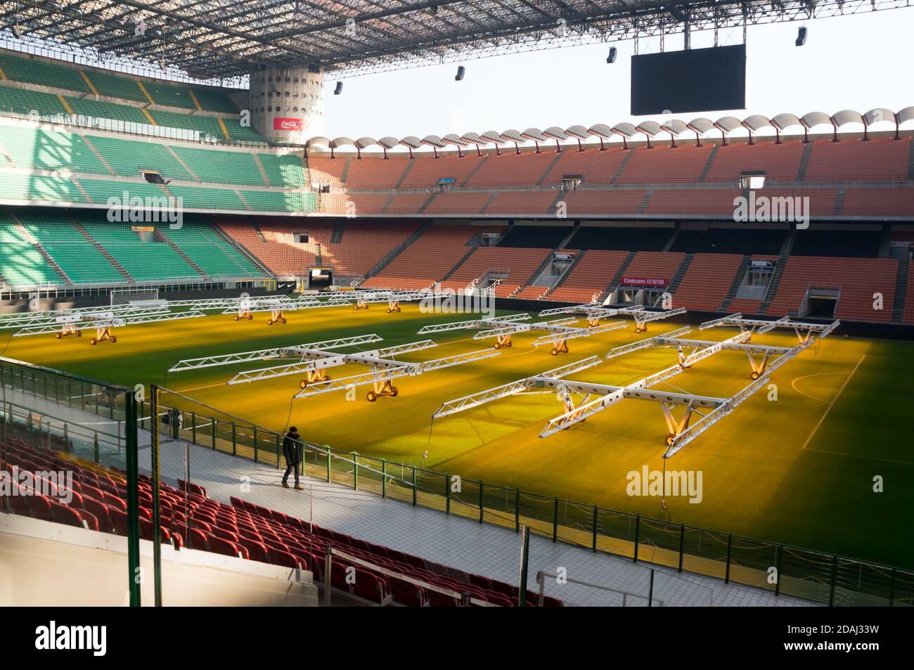 Agronomo cammina lungo l'arena calcistica, con l'installazione mobile di ulteriore illuminazione del prato naturale allo stadio Giuseppe Meazza. Foto Stock