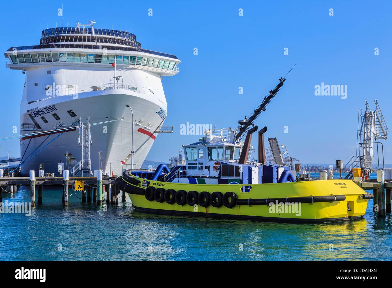 Un rimorchiatore del porto e la nave da crociera 'Carnival Spirit' nel porto di Mount Maunganui, Nuova Zelanda Foto Stock