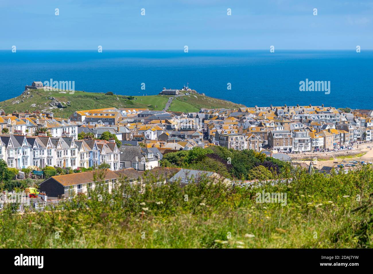 Vista della Cappella di San Nicola e di St Ives Head sull'isola, vista sulle case e gli edifici a St Ives, Cornovaglia, Regno Unito Foto Stock