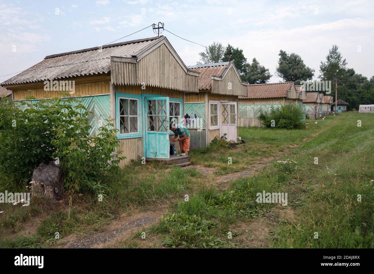 Tourist è sul portico del loggia turistica estiva in legno presso il campo di Iskra nel villaggio di Shushenskoye. Regione di Krasnoyarsk. Russia. Foto Stock