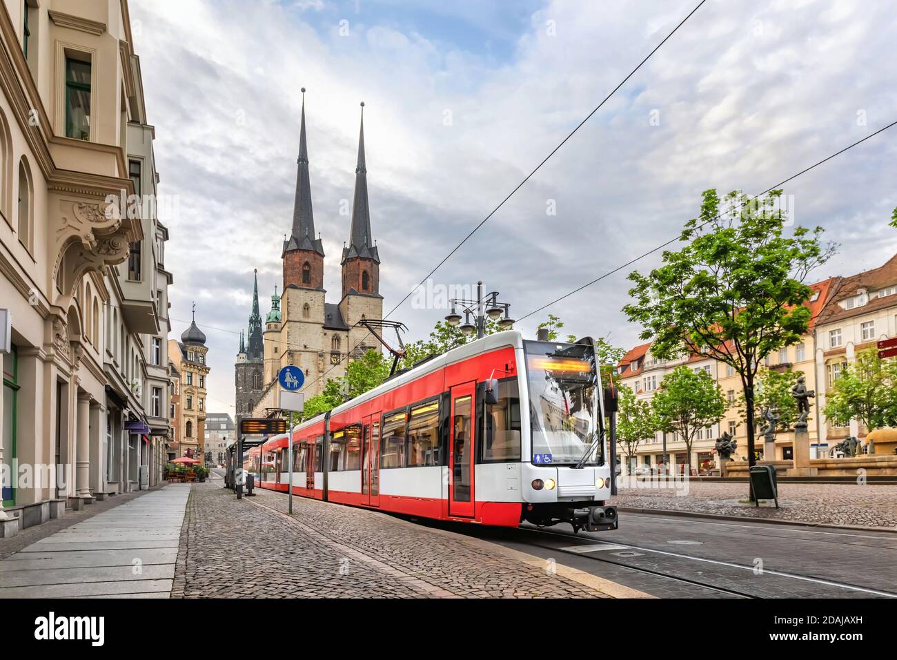 Halle (Saale), Germania. Tram rosso che va su piazza Hallmarkt di fronte alla chiesa di Marktkirche nel centro storico Foto Stock