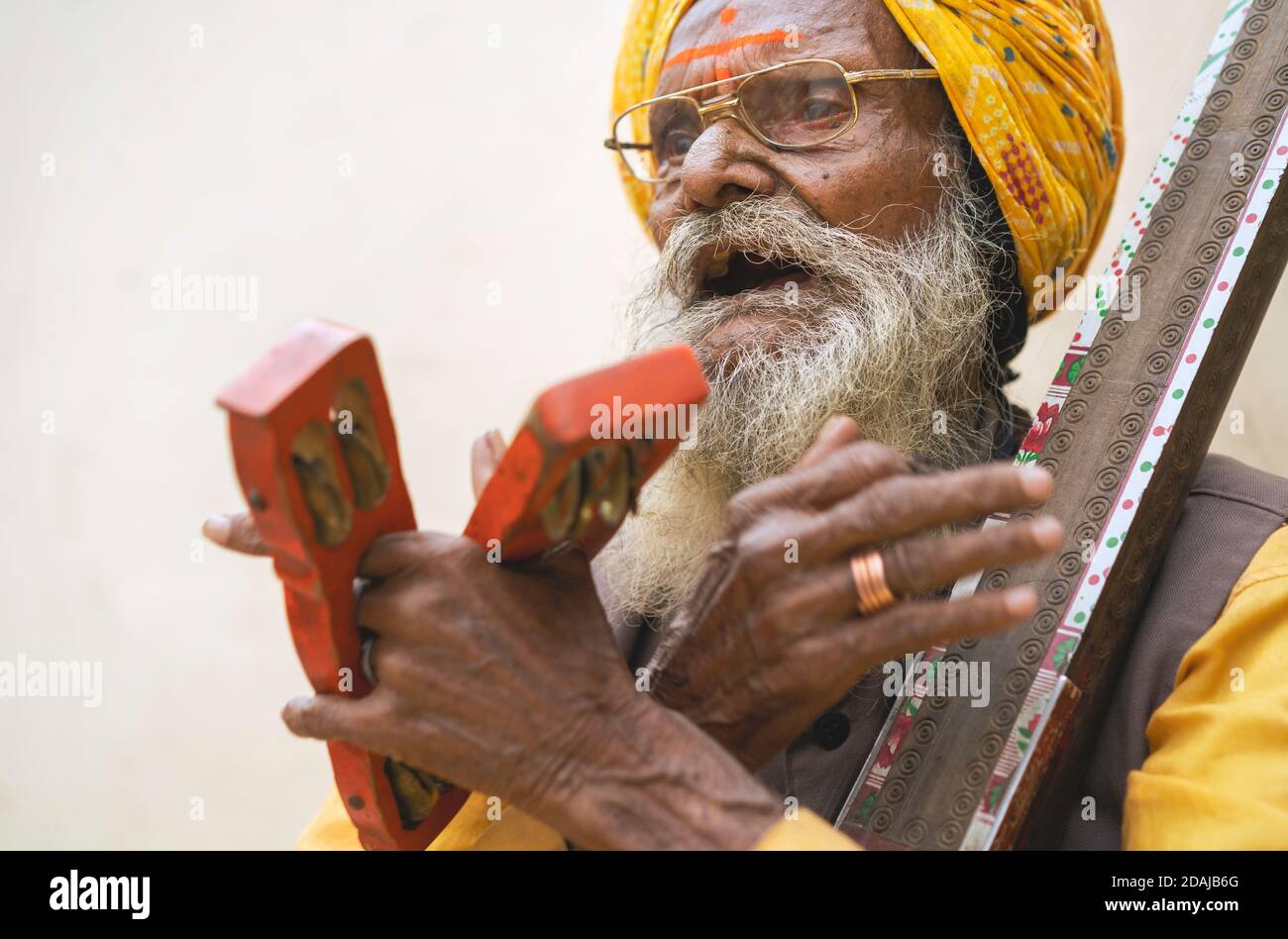 Anziano musicista di strada cantando canzoni tradizionali e musica per intrattenimento turistico il 28 ottobre 2019 a Udaipur, Rajasthan, India. Foto Stock
