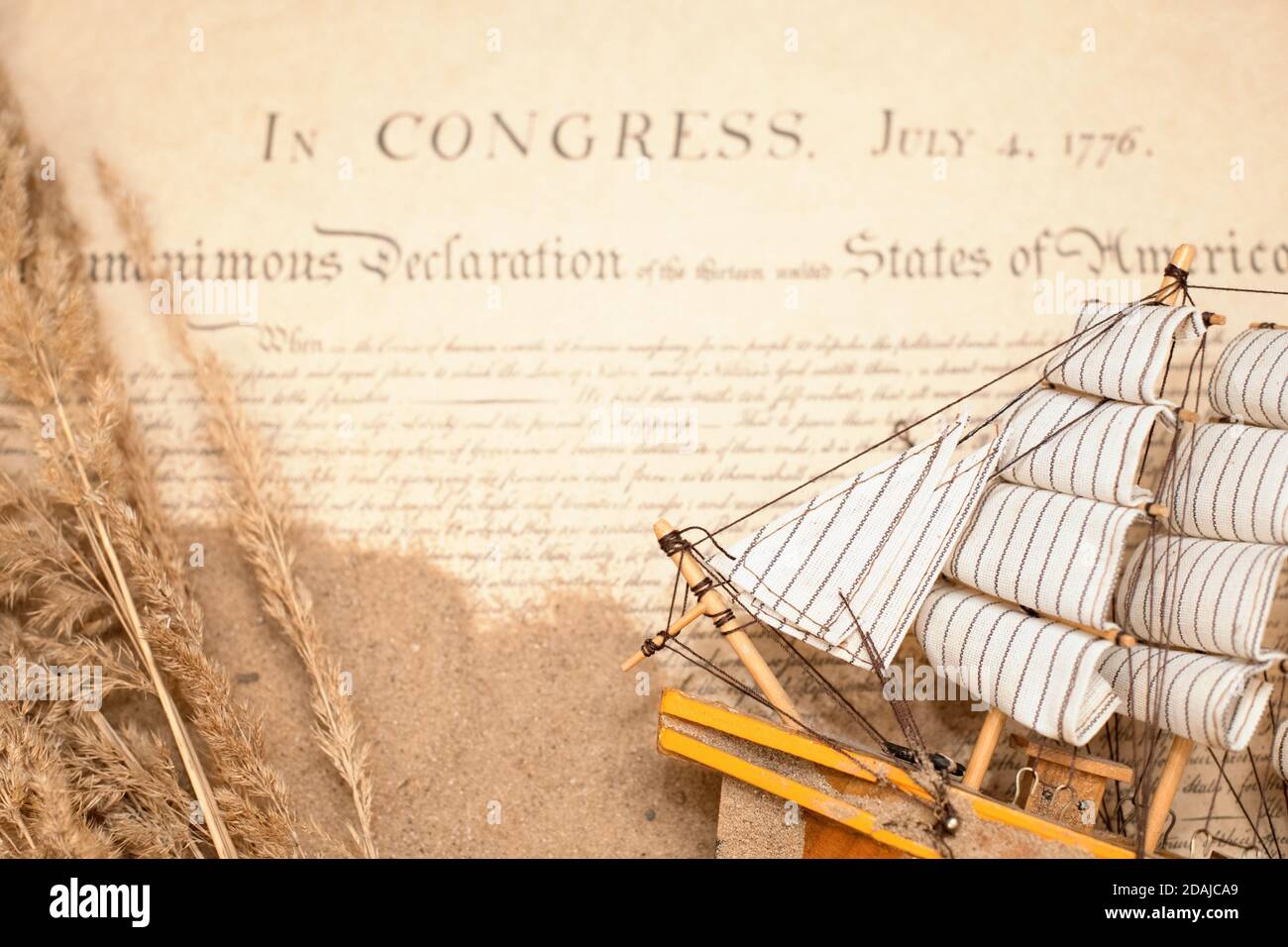 Nave in legno e tessuto fatta a mano sullo sfondo di un estratto da una copia del documento di 1776 sulla firma dell'indipendenza del Foto Stock
