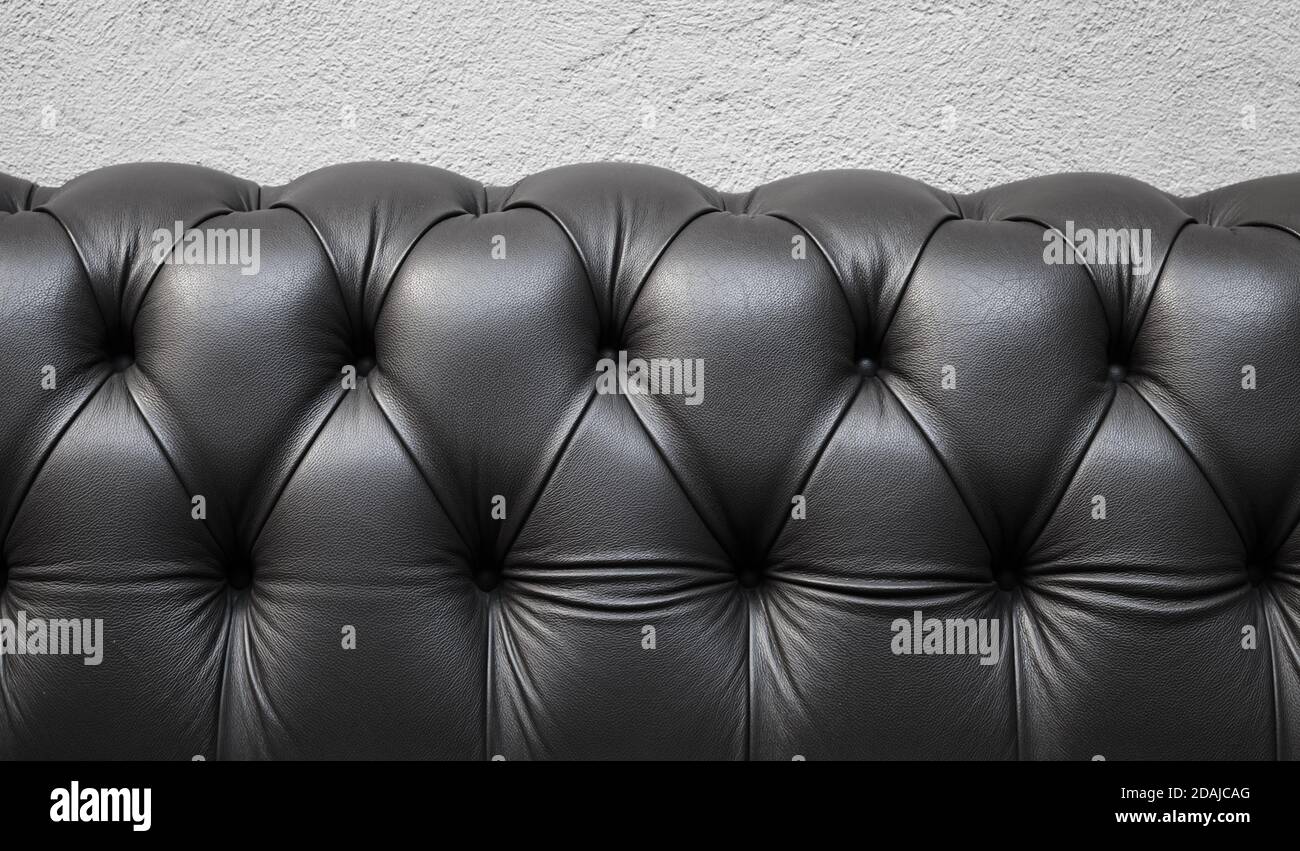 Il retro di un divano con morbida tappezzeria nera in pelle, trama foto di sfondo Foto Stock