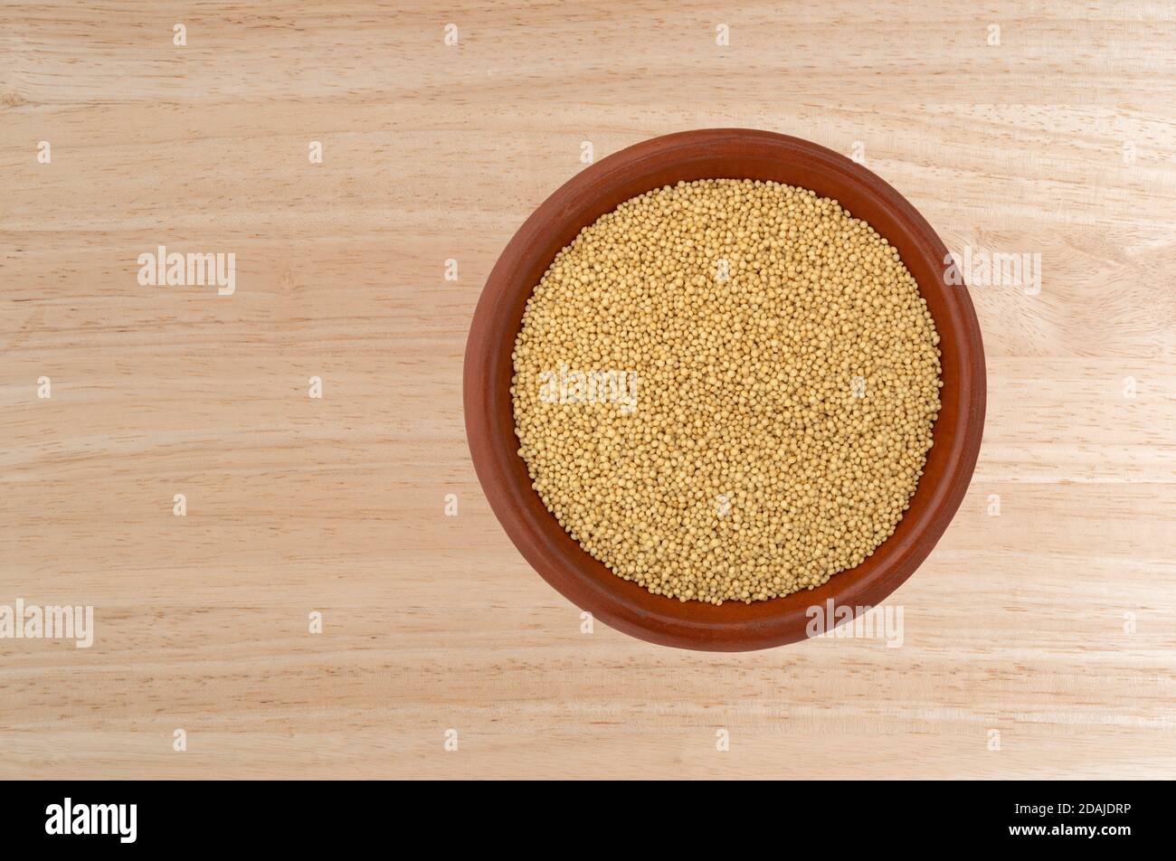 Vista dall'alto dei semi di amaranto in una piccola ciotola su un piano di legno. Foto Stock