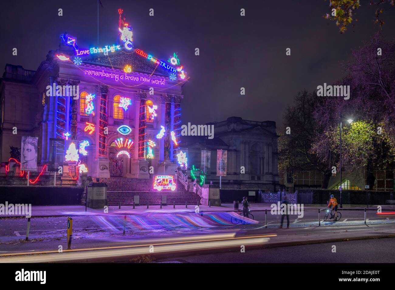 Tate Britain, Londra, Regno Unito. 13 novembre 2020. La nuova Tate Britain Winter Commission, ideata dall'artista inglese Chila Kumari Singh Burman, si ispira al suo patrimonio Punjabi e alla classe operaia Liverpudliana, esplorando la molteplicità delle identità del Sud asiatico in un contesto britannico decorando il portico della galleria in un'atmosfera di colore. I ciclisti che passano la mattina presto si fermano per fotografare il lavoro. Credito: Malcolm Park/Alamy Foto Stock