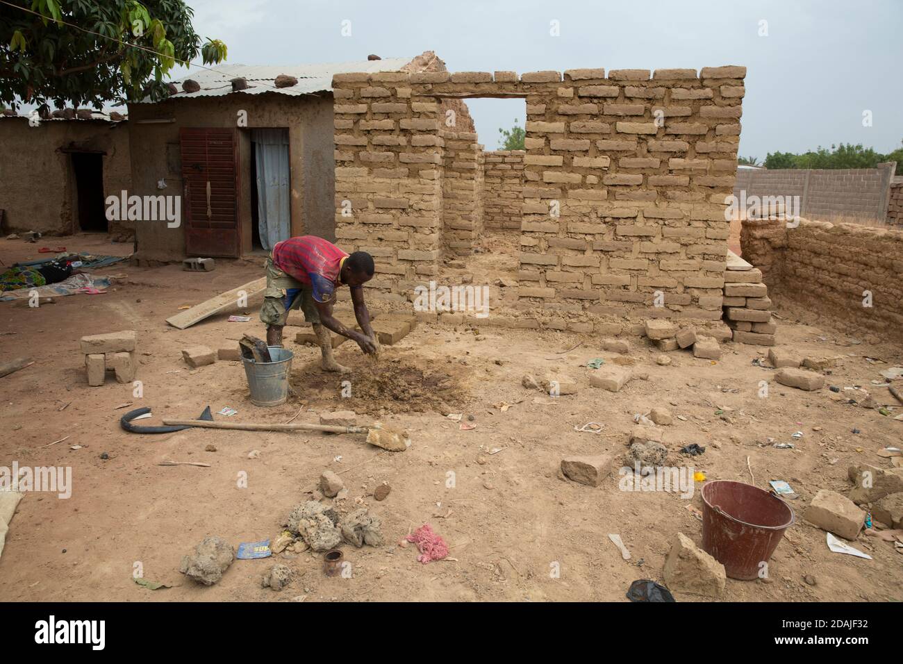 Selingue, Mali, 26 aprile 2015; Madou Sidibe, 25 Costruire una casa per il suo fidanzato, Kadiatou Sogoba, 17. Lavora come lavoratore per un costruttore di case. Foto Stock