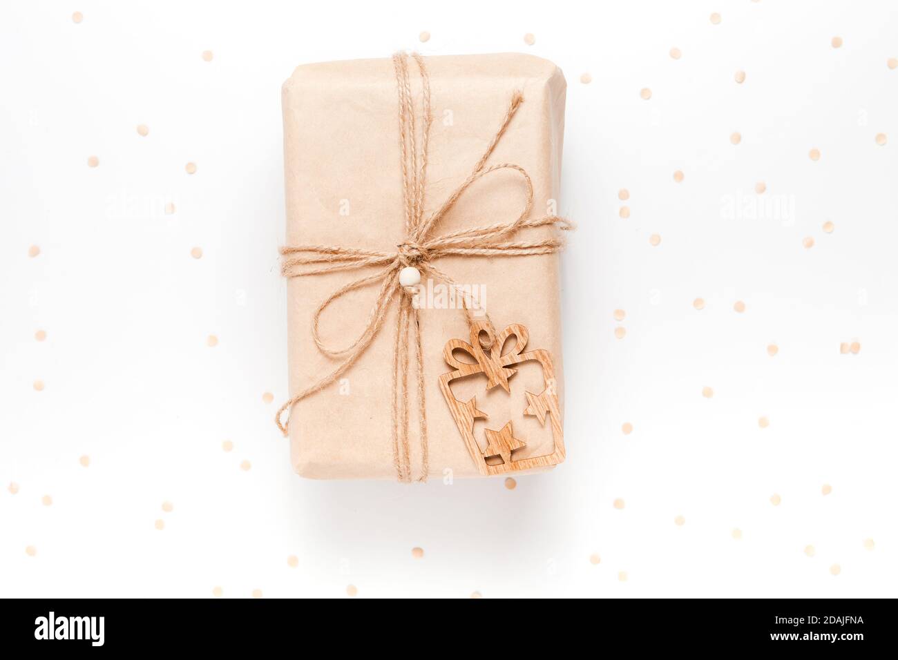 Confezione regalo avvolta in carta artigianale su sfondo bianco con confetti Foto Stock