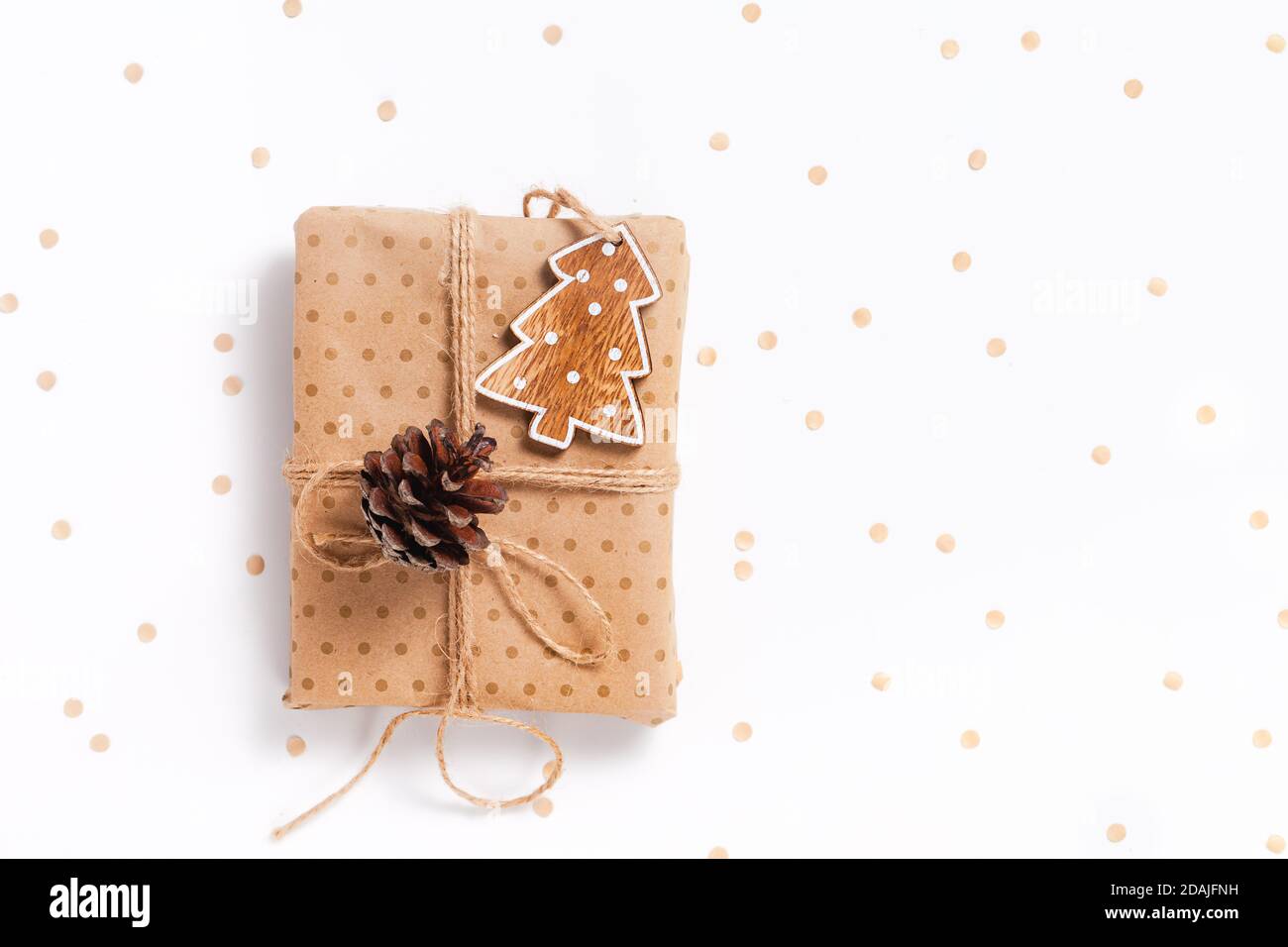 Confezione regalo avvolta in carta artigianale con decorazioni su sfondo bianco, disposizione piatta con spazio per la copia Foto Stock