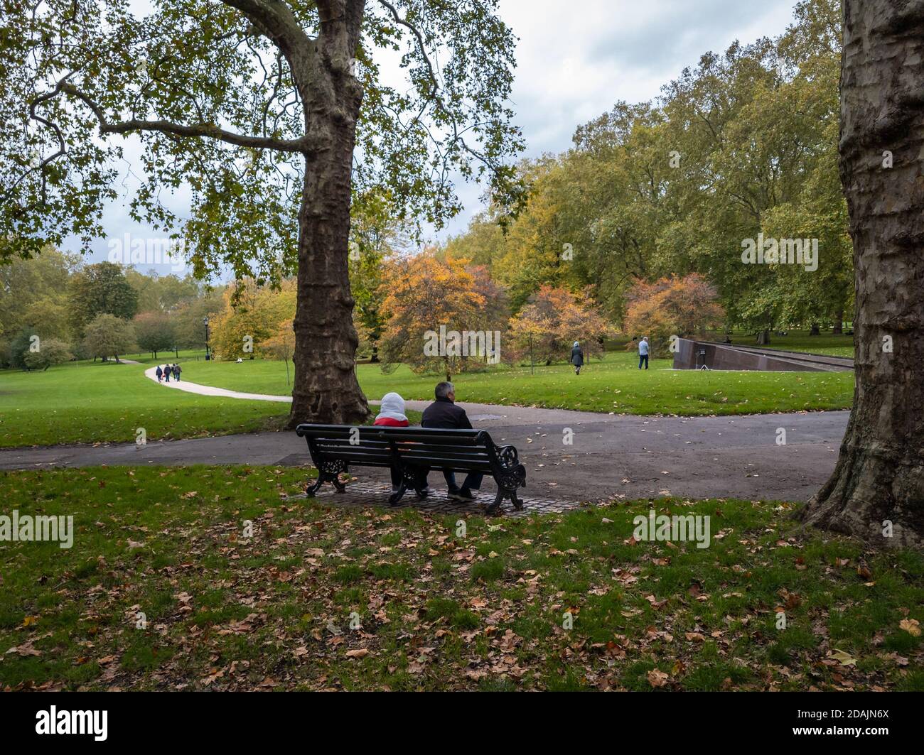 Una coppia seduta su una panchina a Green Park. Londra. Foto Stock