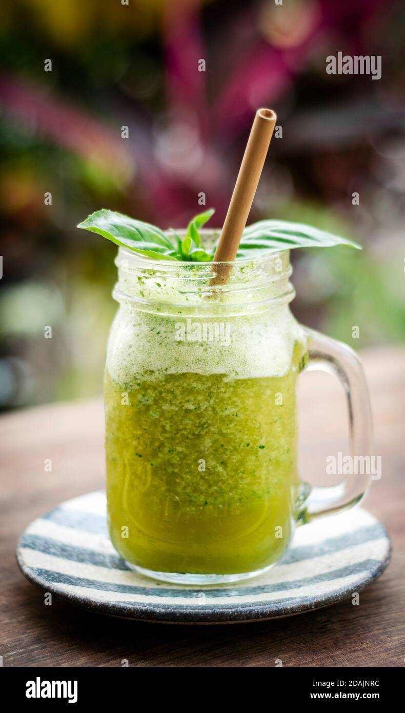 kiwi di ananas organico e frutta di basilico detox bevanda sana del frullato all'aperto in vetro Foto Stock