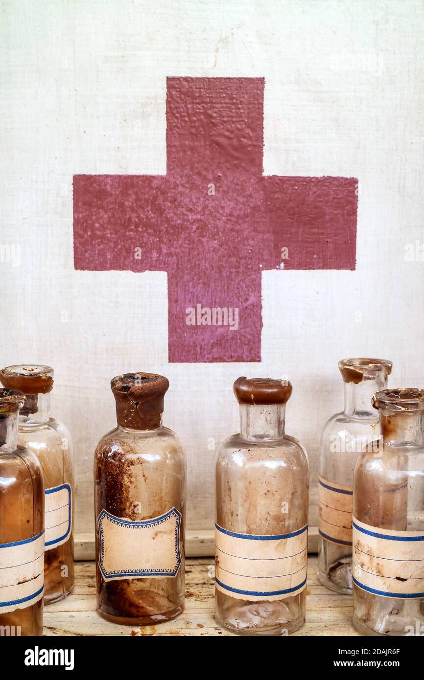 Vecchi flaconi di farmacia di fronte a un armadio di medicina Foto Stock