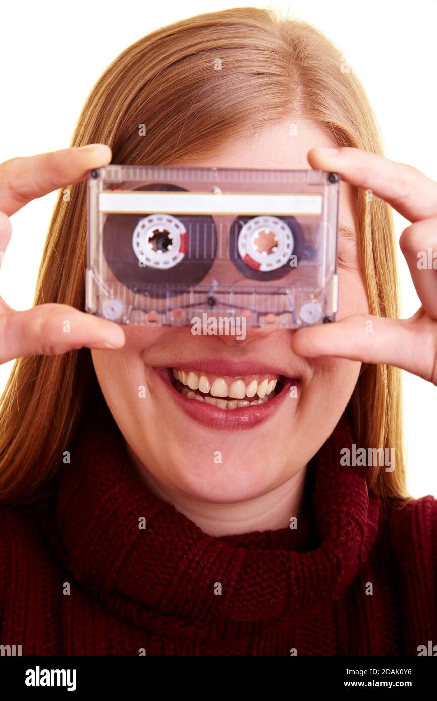 Donna ridente tiene una cassetta audio davanti a lei faccia Foto Stock