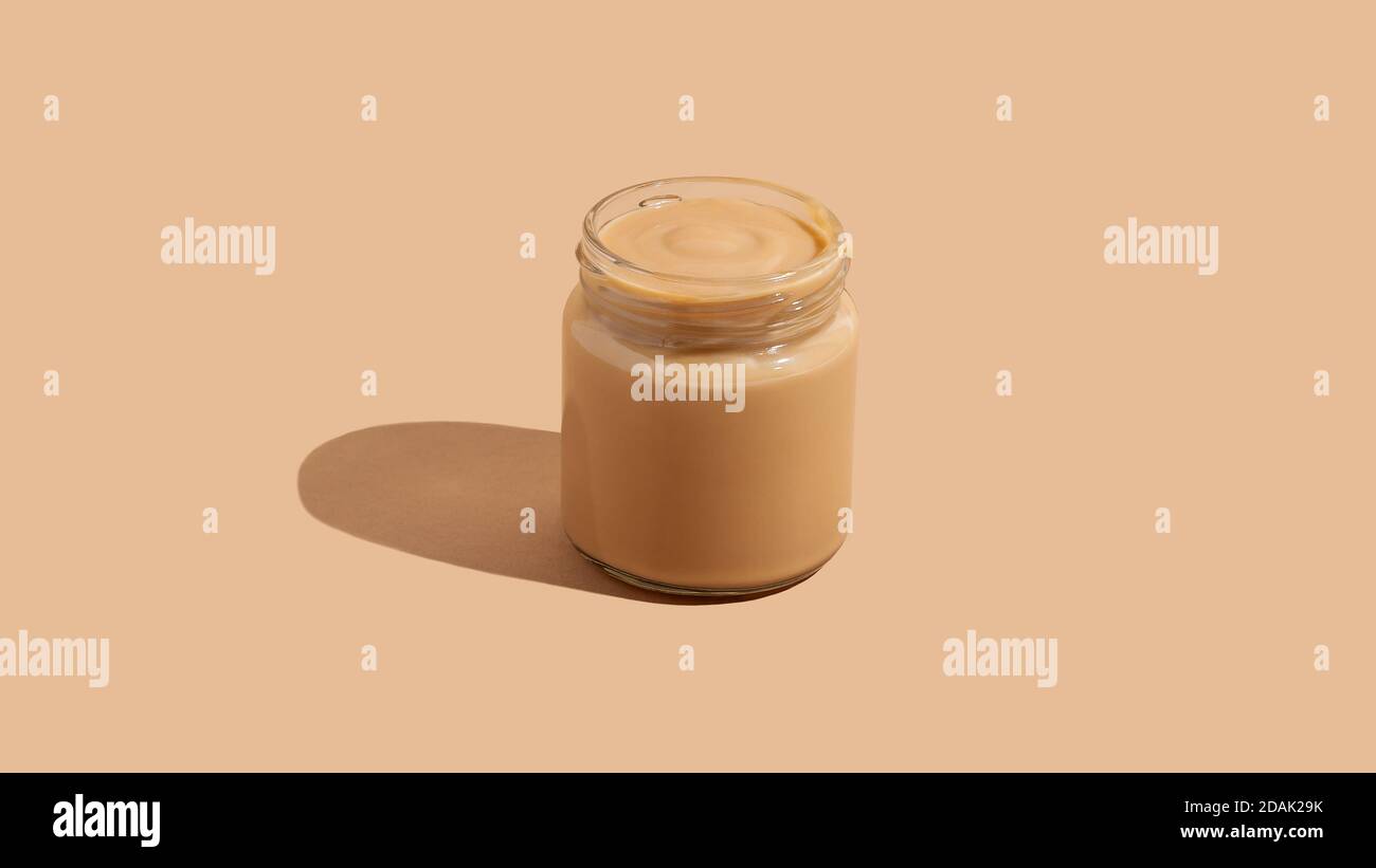 Dessert al budino di yogurt in vasetto di vetro su sfondo beige con spazio per la copia. Minimalismo cibo concettuale ancora vita Foto Stock