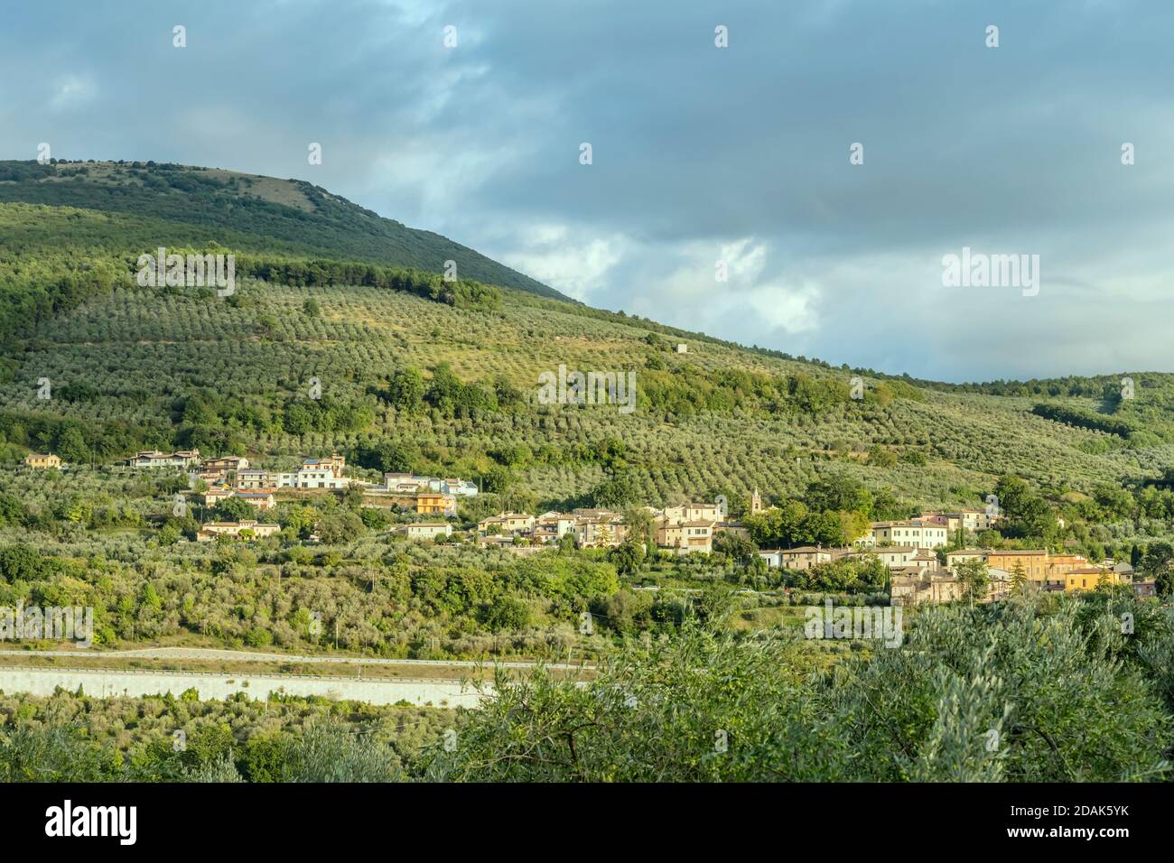 Paesaggio con borgo di S.Lazzaro tra oliveti in campagna collinare, girato in luce intensa vicino a Foligno, Perugia, Umbria, Italia Foto Stock