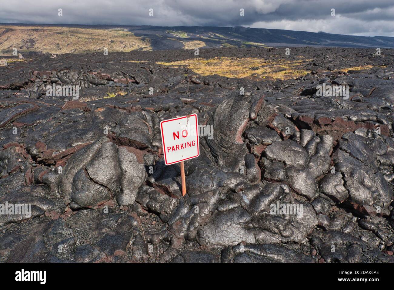 Flusso di lava solidificato sulla costa orientale di Big Island con un segnale di parcheggio quasi sepolto, Hawaii Island, Hawaii Foto Stock