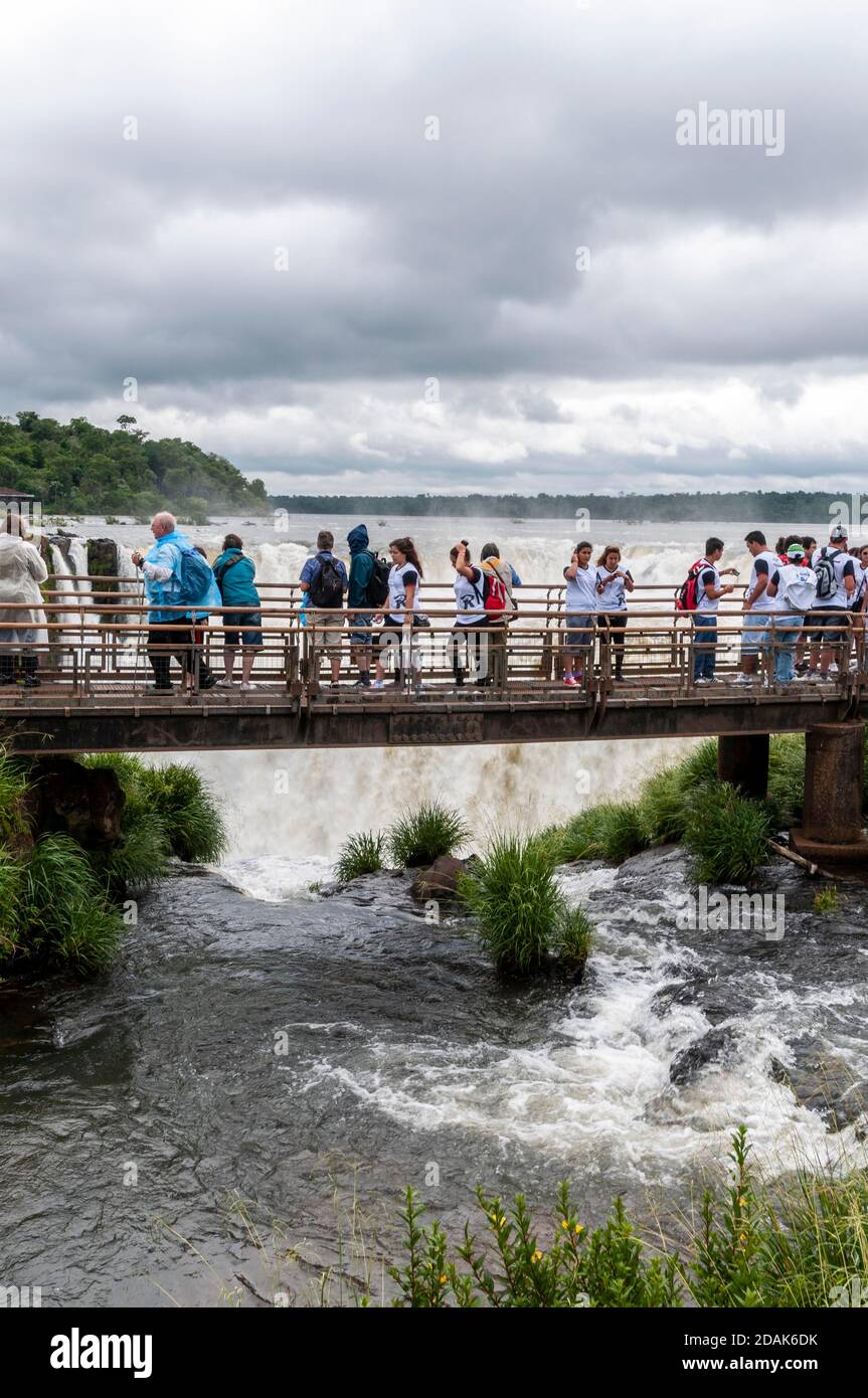 I visitatori su una piattaforma panoramica sopra le Cascate della Gola del Diavolo alte 82 metri, parte delle Cascate di Iguazu nel Parco Nazionale di Iguazu sul Foto Stock