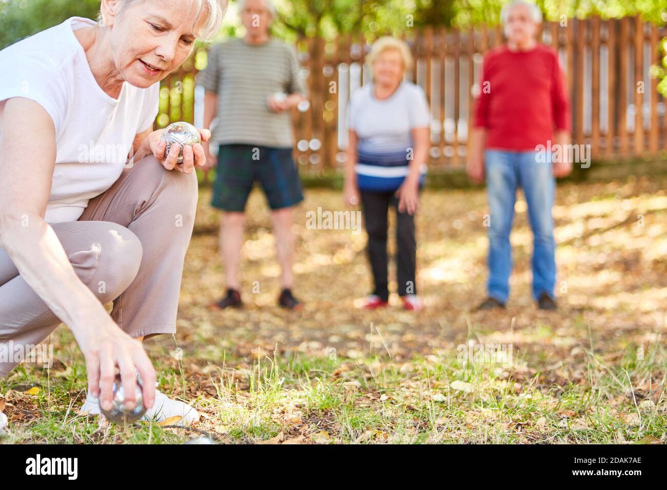 Gruppo senior che gioca boules in giardino come un hobby o come concorrenza Foto Stock