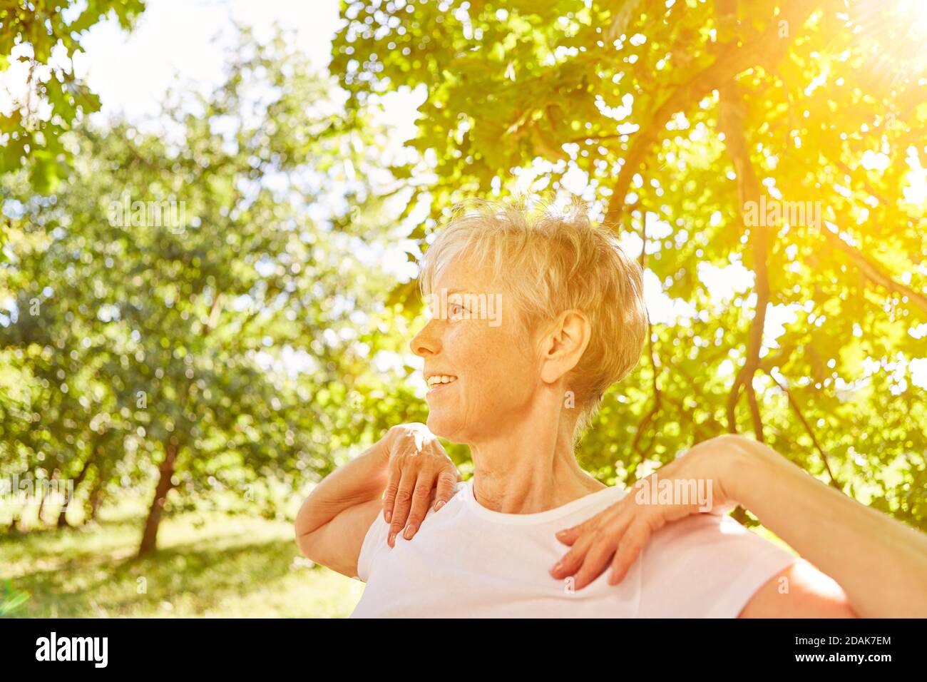 Donna anziana attiva felice che fa ginnastica sport all'aperto in natura Foto Stock