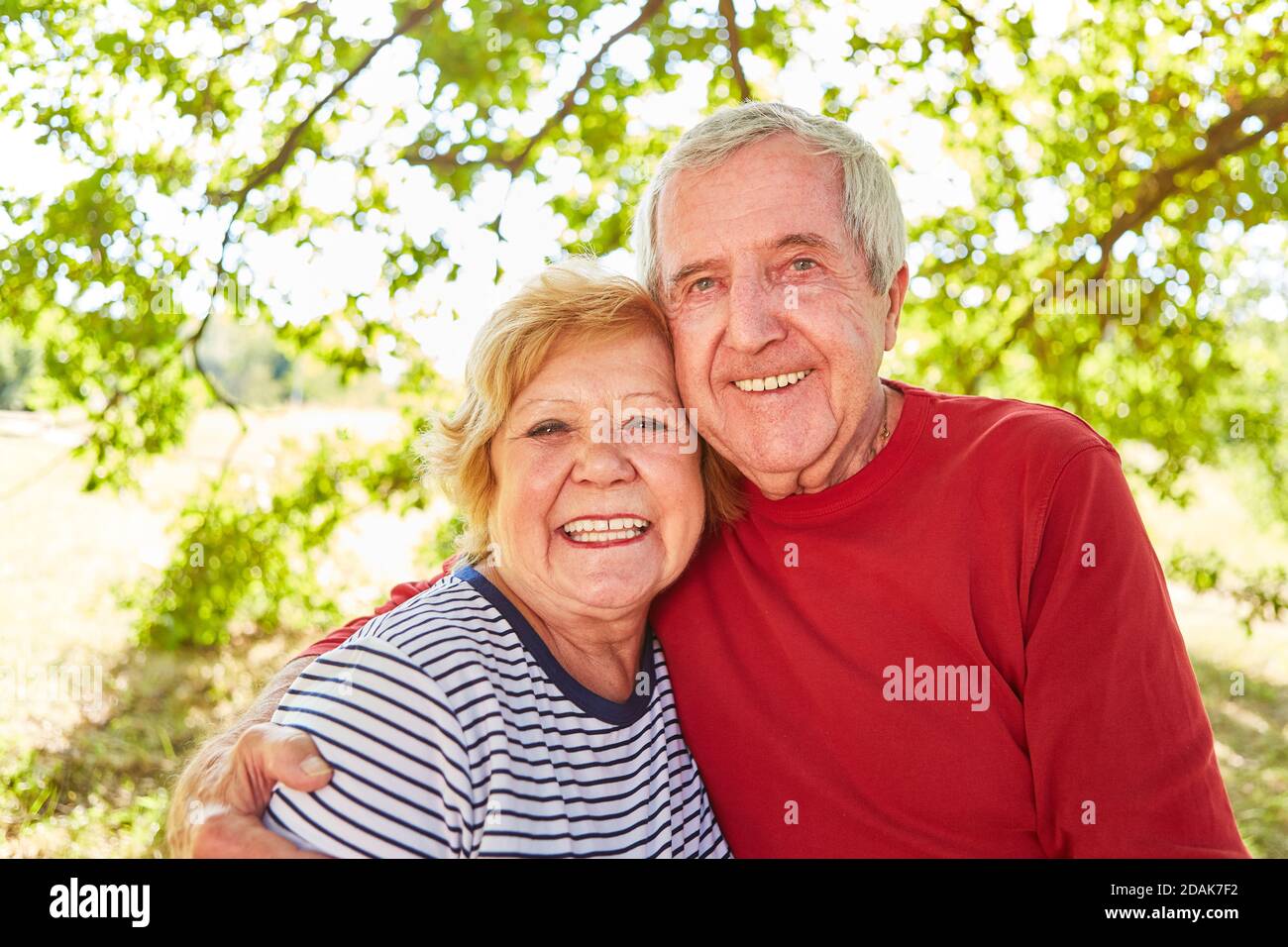 Felice coppia senior in amore braccio in piedi dentro il parco in estate Foto Stock