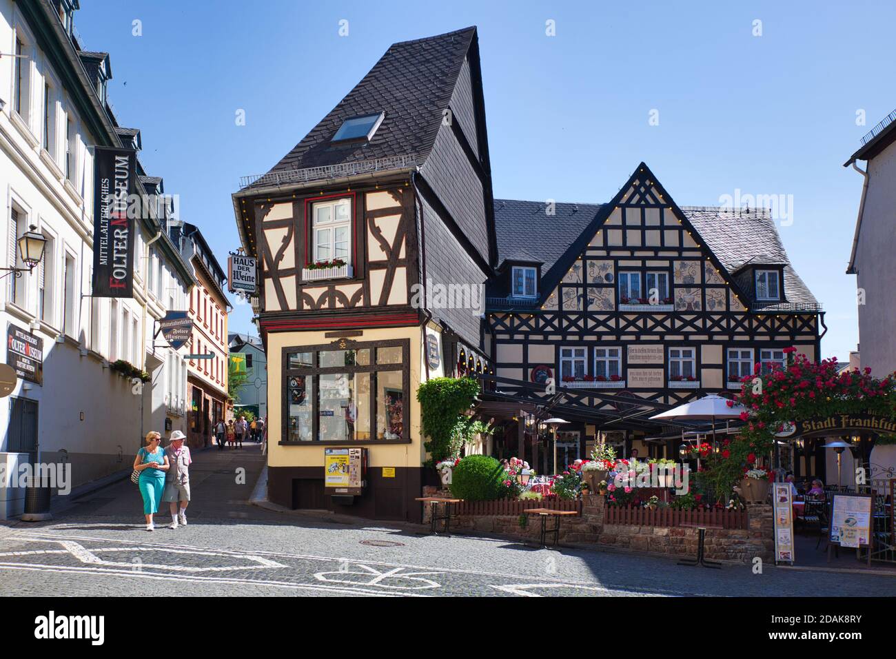 Una piccola piazza con due persone, interessanti case decorative con tetti alti e strada stretta che conduce a Rudesheim, Darmstadt, Heese, Germania Foto Stock