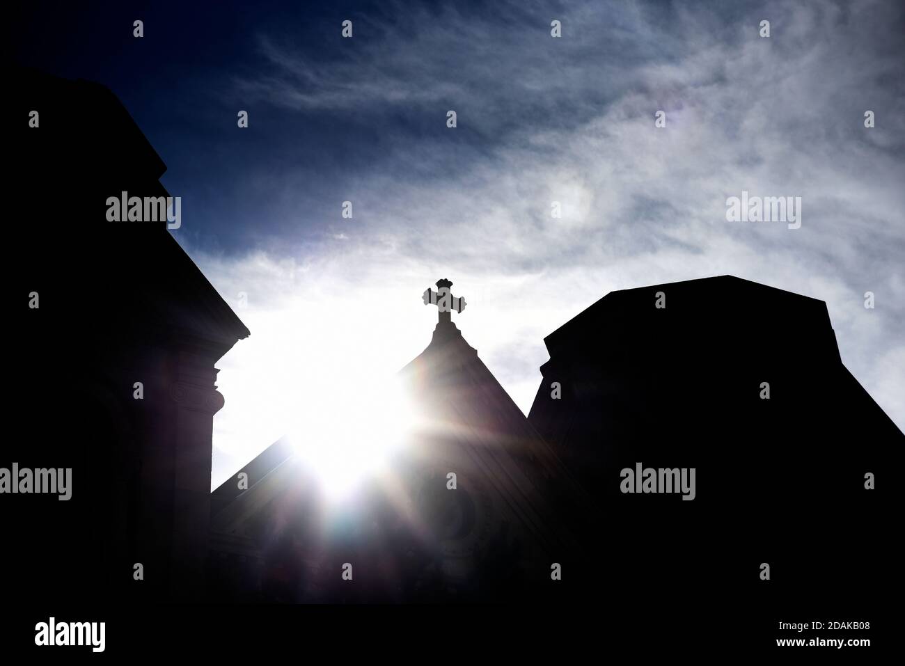 Il sole del mattino sorge dietro la croce di pietra in cima alla Basilica Cattedrale di San Francesco d'Assisi a Santa Fe, New Mexico. Foto Stock