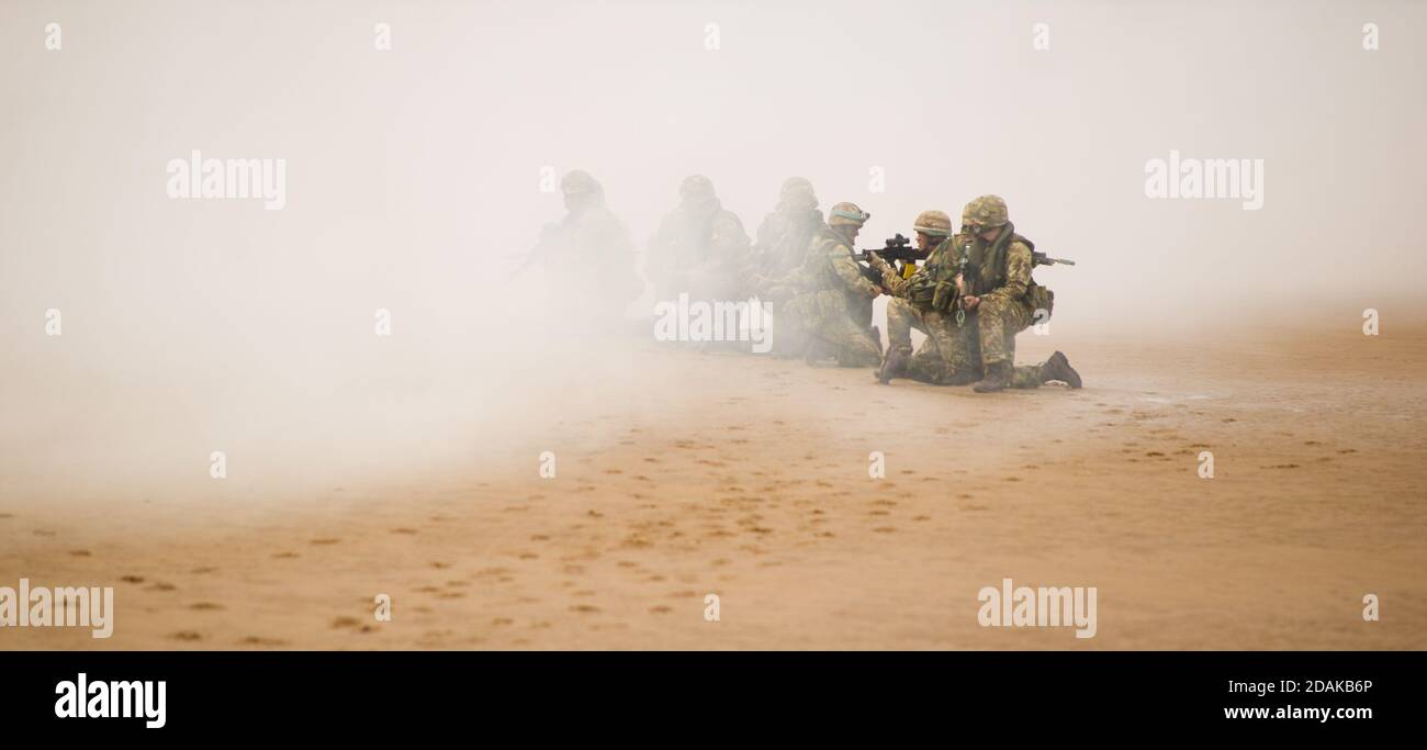 Royal Marine Commandos allenarsi prepararsi a muoversi sotto la copertura di fumo Foto Stock