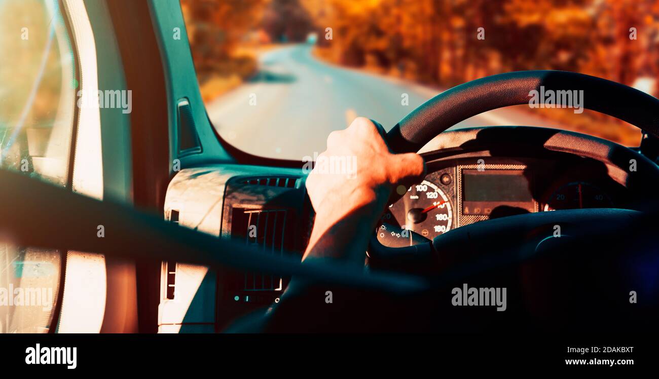 Driver e strada di montagna in autunno season.Image relativo ai viaggi di strada.particolare della mano dell'uomo al volante Foto Stock