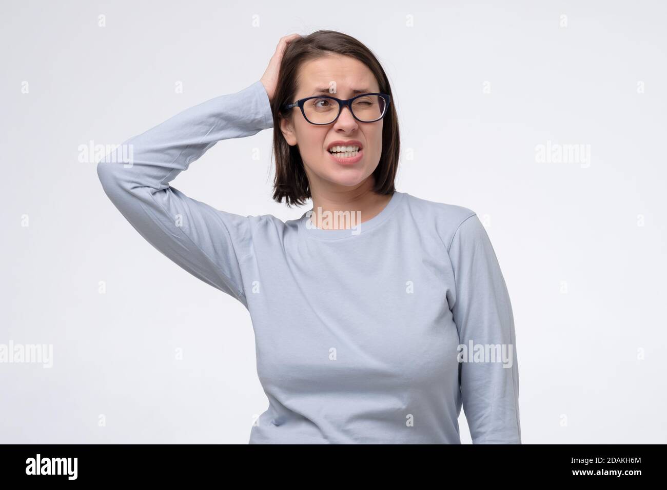 Donna matura con gli occhiali che graffiano la testa, pensando daysognando profondamente su qualcosa Foto Stock