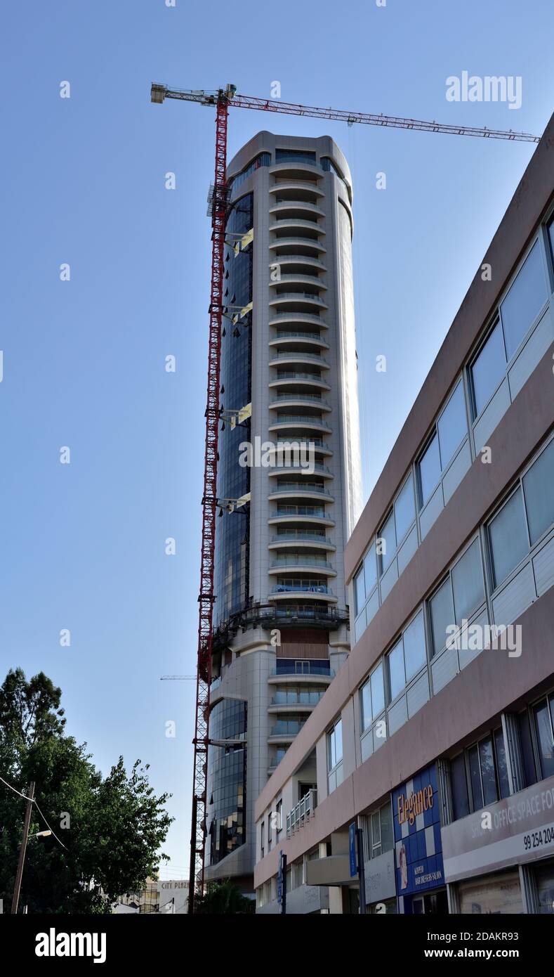 Edificio moderno con grattacieli con gru alta sopra la prossima costruzione, Nicosia, Cipro Foto Stock
