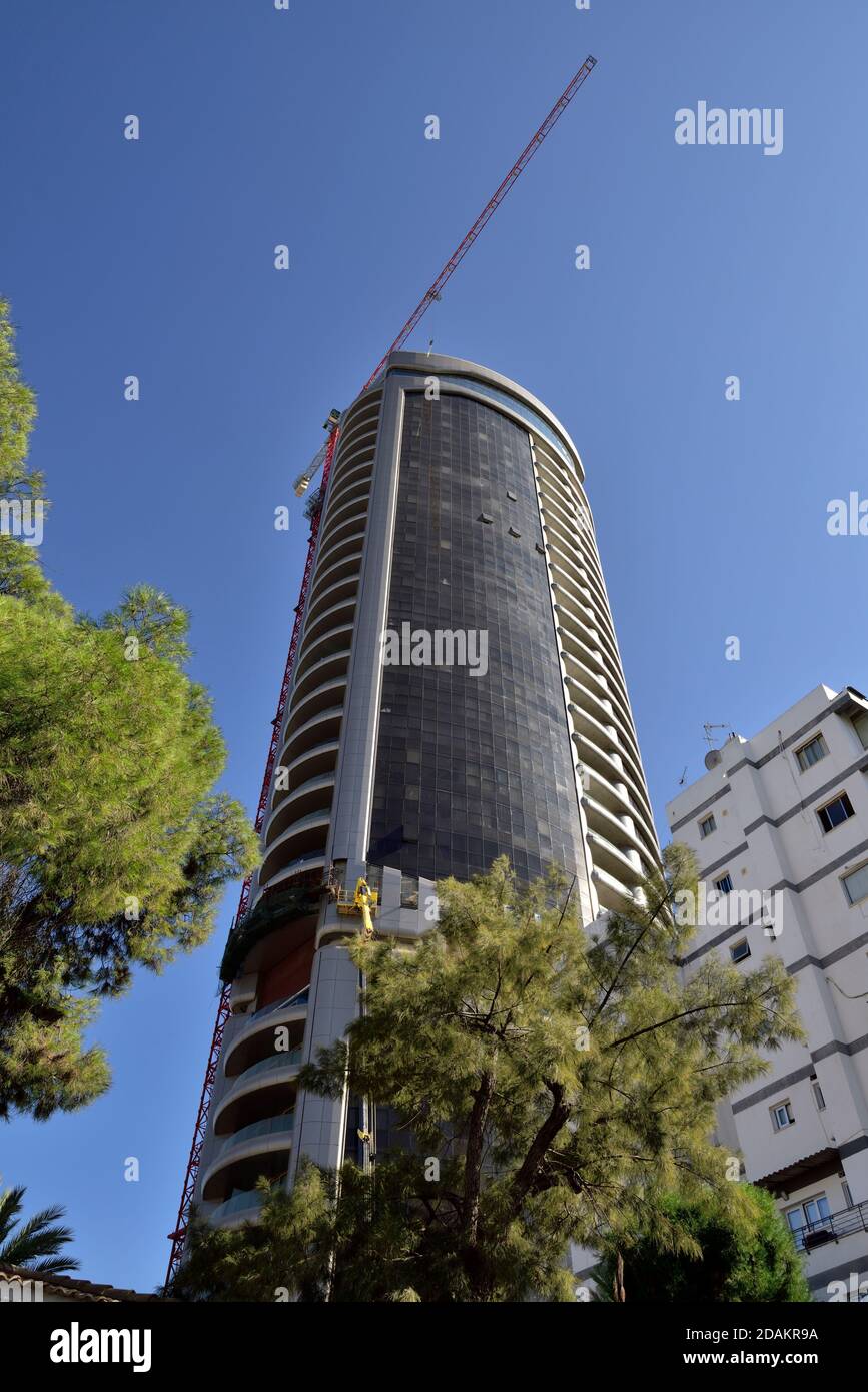 Edificio moderno con grattacieli (360 Nicosia) con gru alta sopra l'approssimarsi del completamento della costruzione, Nicosia, Cipro Foto Stock