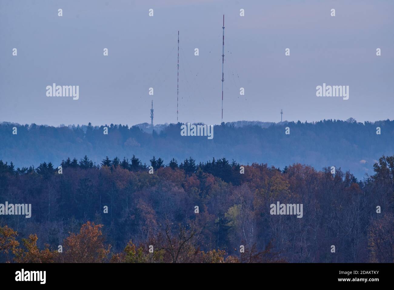 Torre televisiva su una collina in lontananza. Paesaggio autunnale durante l'ora blu. Foto Stock