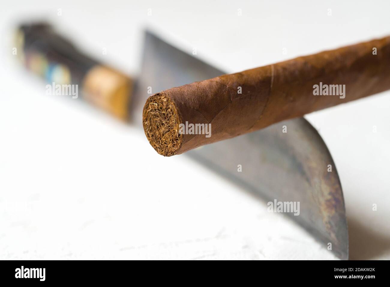 Bilanciamento del sigaro sul bordo di un coltello. Il concetto di pericoli del fumo. Foto Stock