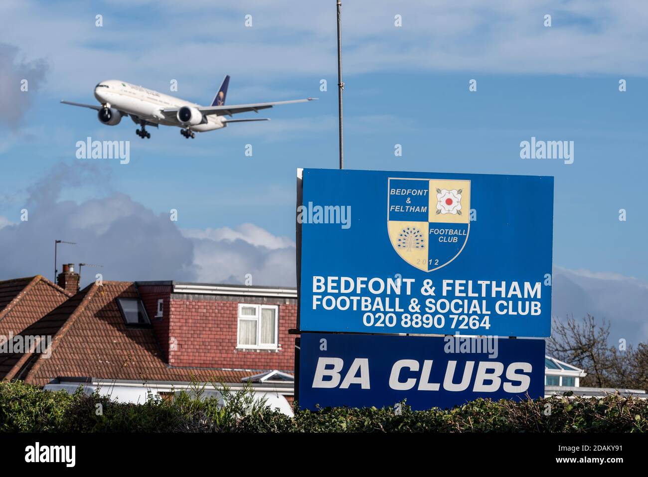 Aereo jet Airliner in avvicinamento per atterrare all'aeroporto Heathrow di Londra, Regno Unito, oltre Bedfont & Feltham Football & Social Club. BA Club. Basso sopra casa Foto Stock
