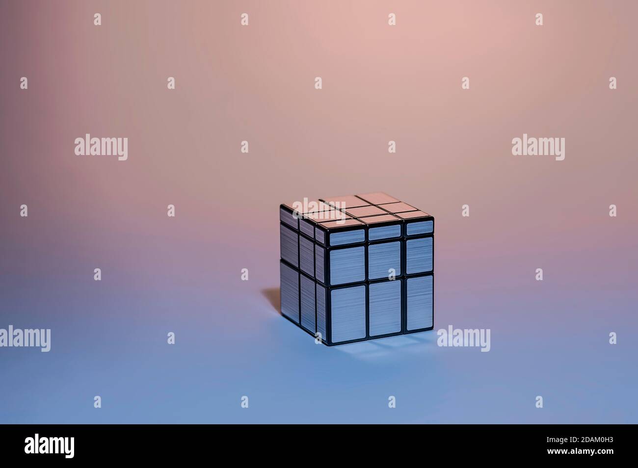 Mirror Silver Cubo di Rubik su sfondo rosa e blu gradiente, Magic Cube, Puzzle Cube Foto Stock