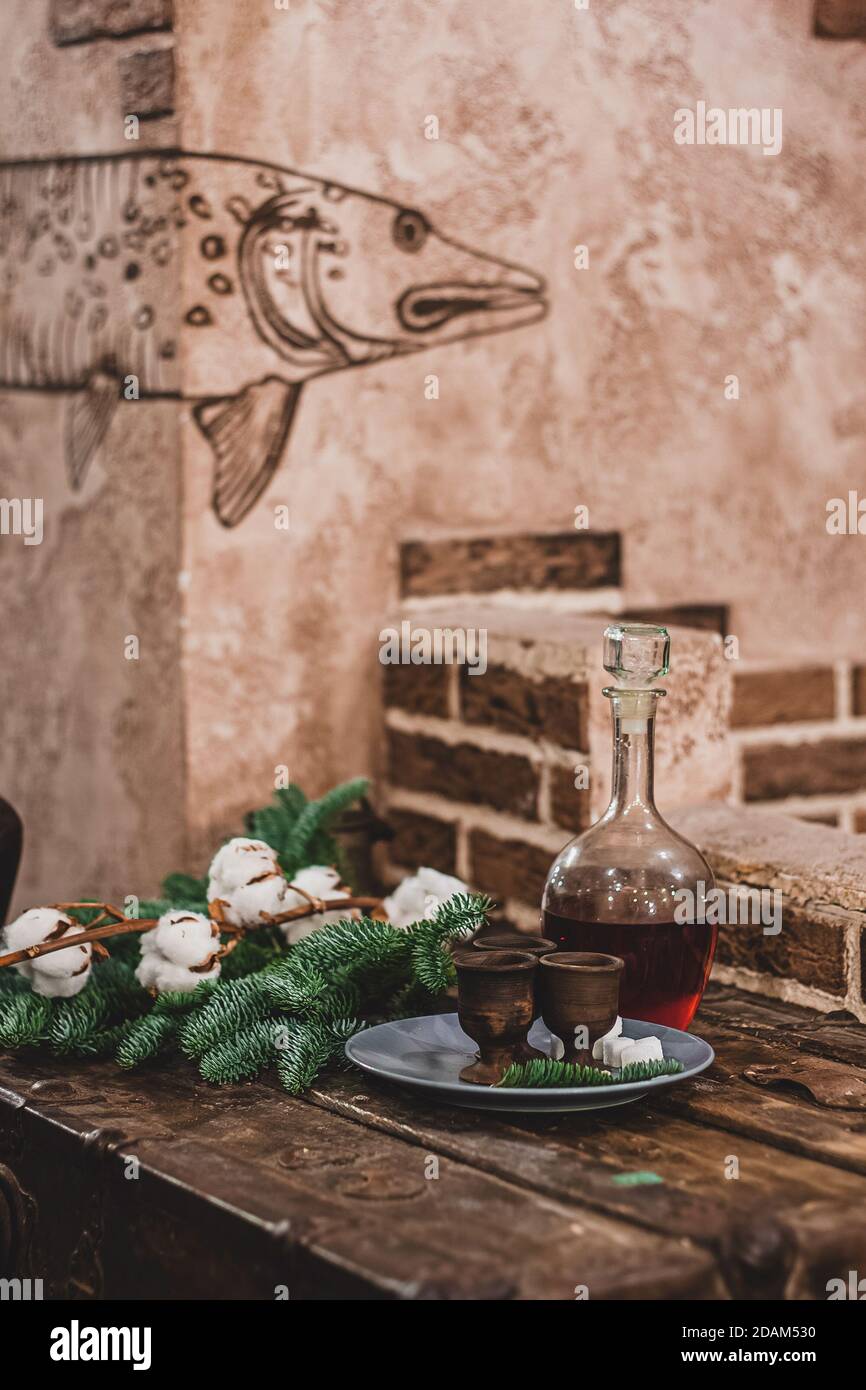 Sfondo vintage di Natale, bevanda alcolica artigianale e piatti antichi, rami di abete soffici e arredamento festoso. Foto Stock