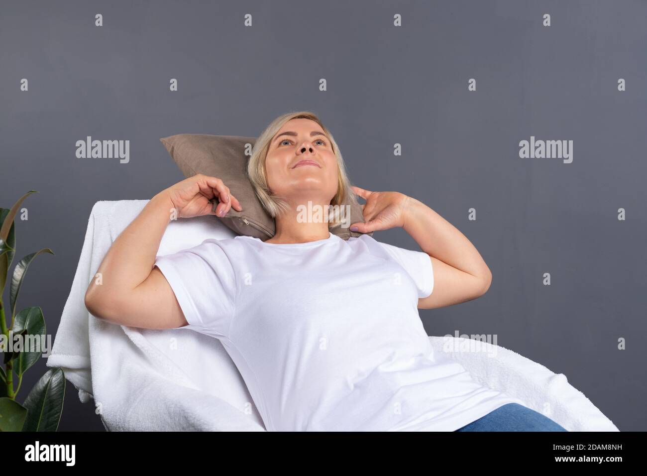 Calma vecchia donna si rilassa su una comoda poltrona a casa, felice donna riposa e sogni, si appoggia indietro. Foto Stock