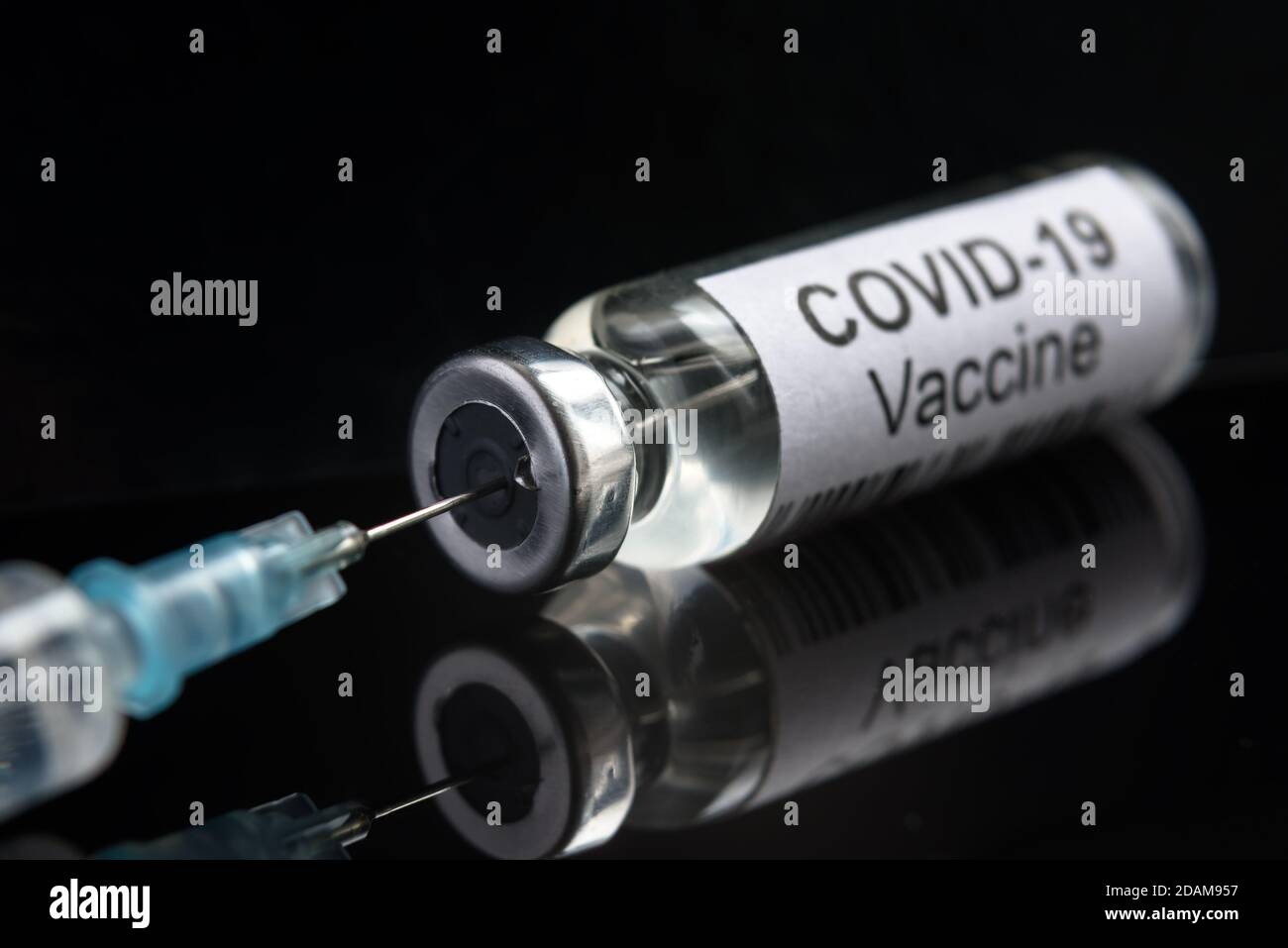 Vaccino COVID-19 su close-up nero, siringa e flacone con vaccino per la cura del coronavirus. Concetto di ricerca del virus corona, trattamento, iniezione, shot Foto Stock